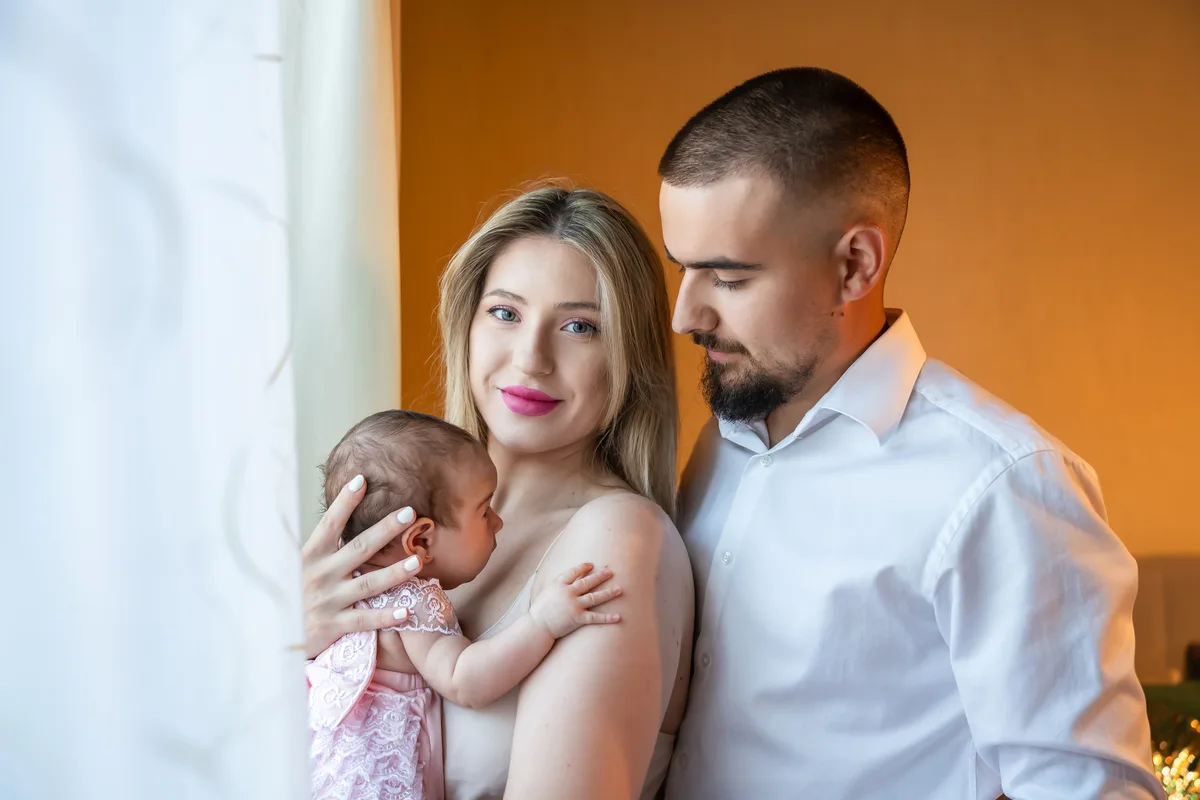 Pregătiri de botez acasă, Roman – mama cu bebelușa în brațe, tatăl privindu-le