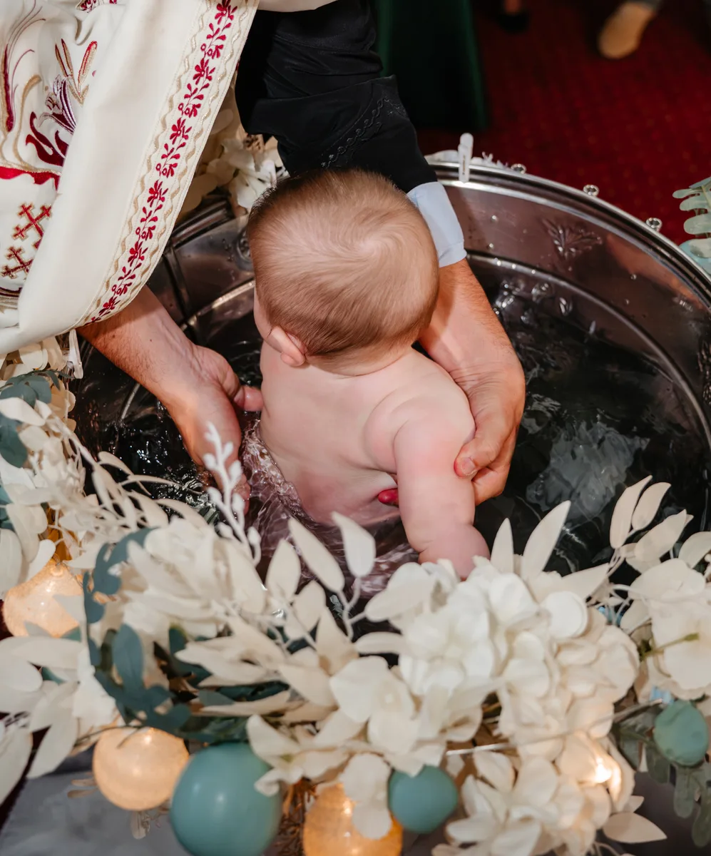 Fotograf botez Roman – scufundarea în cristelniță la Biserica Sfinții Voievozi